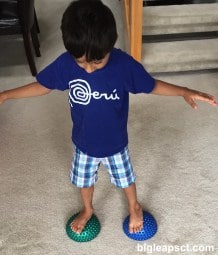 kid balancing on tactile balls