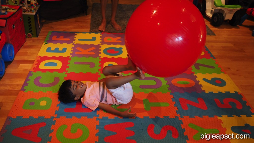 kid kicking pilates ball