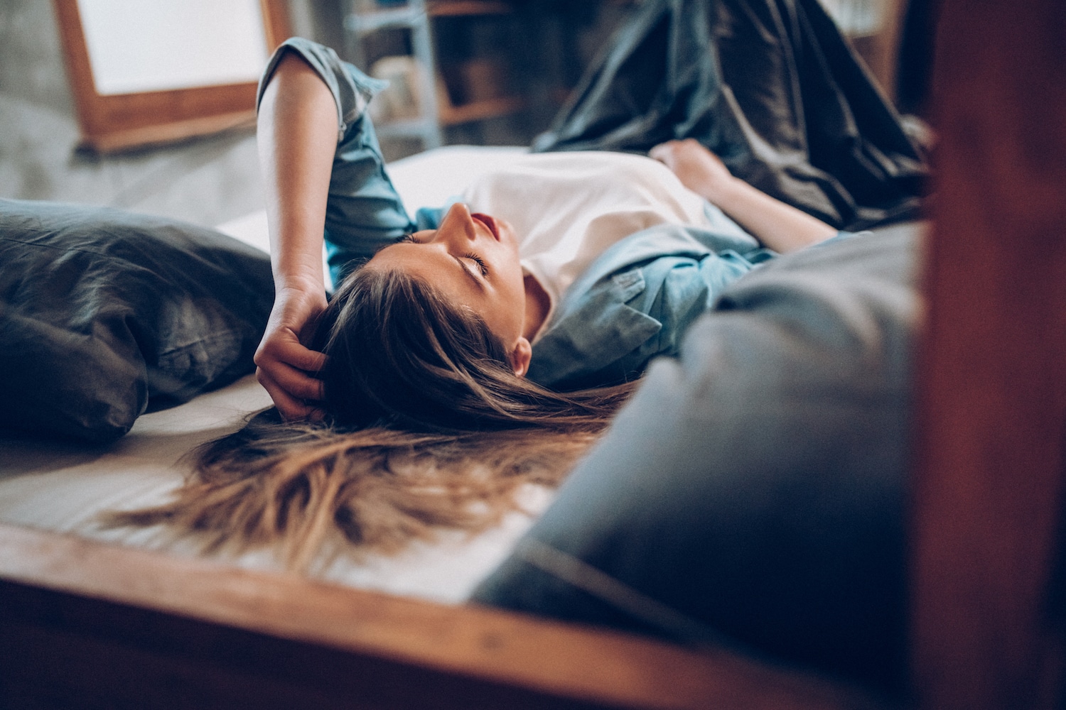 young woman laying on bed